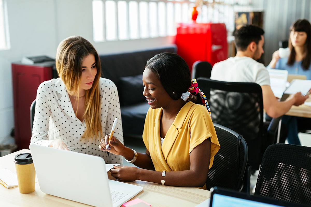 A smiling young woman prepares to sign a contract with a manufactured housing insurance specialist.
